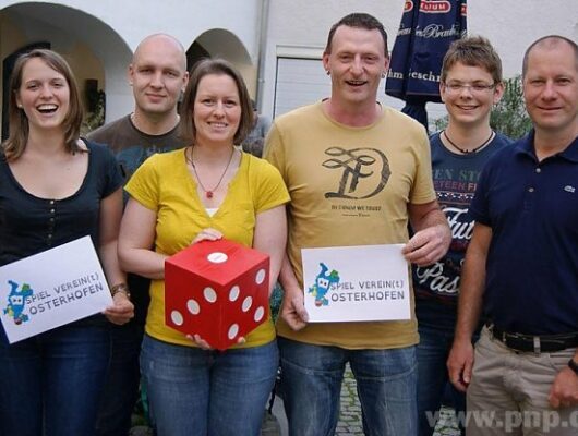 6 Menschen die nebeneinander stehen und jeder hält etwas in der Hand