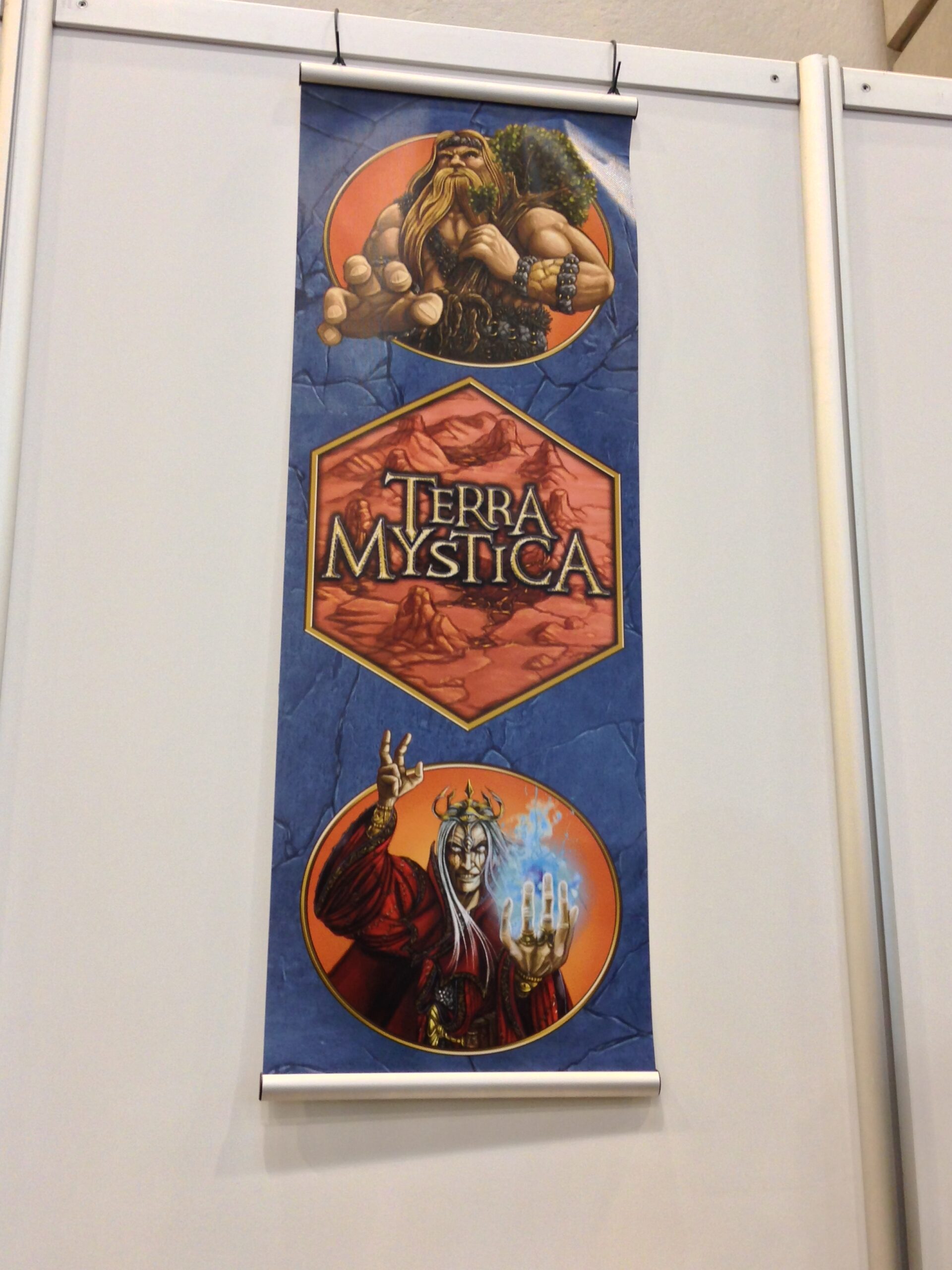 Längliches blaues Terra Mystica Banner an weißer Wand